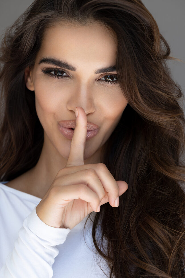 Portrait einer Frau mit Finger auf Lippen – Cynosure Kampagne von Portraitfotograf Hamburg
