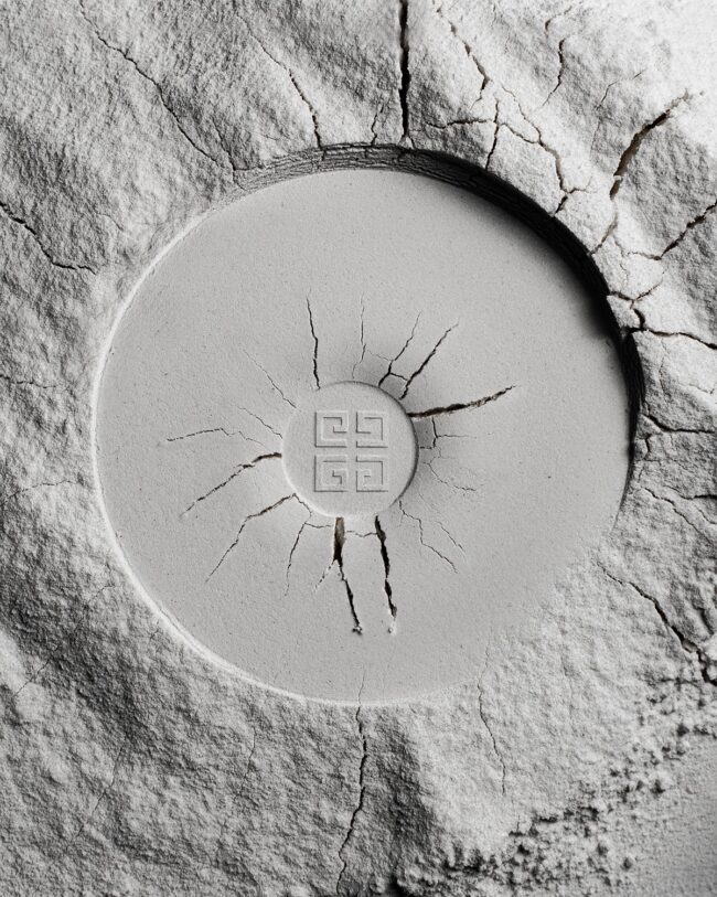 Givenchy Kompaktpuder mit Logo, eingebettet in gesprungene Puderstruktur auf hellem Untergrund