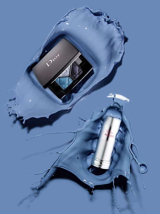 Dior Lidschattenpalette und Lancôme IN LOVE Lippenstift auf dynamischem blauen Hintergrund mit Farbspritzern